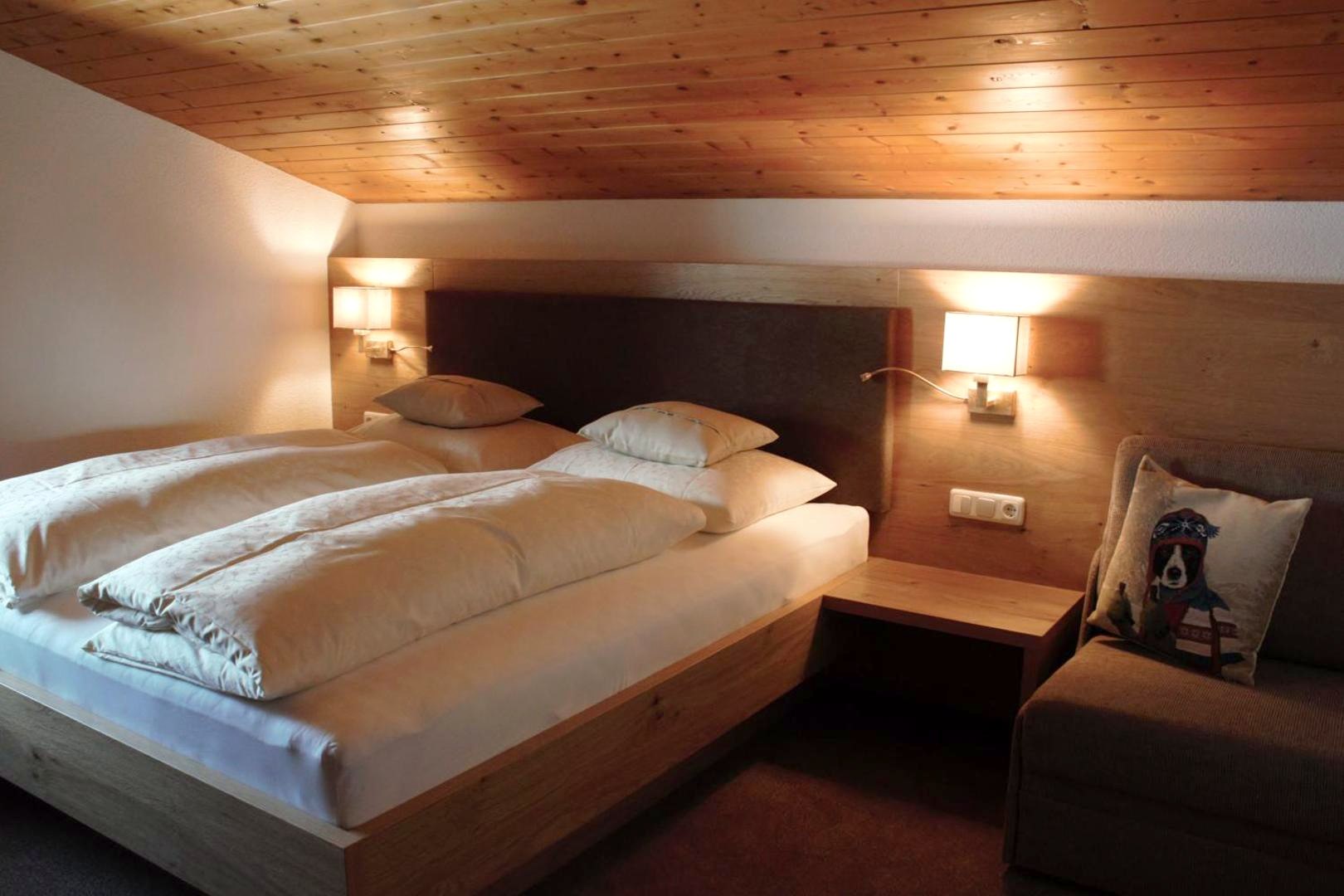 Gemütliches Schlafzimmer mit Holzdecke in der Mansarden-Ferienwohnung III im Haus Biberkopf, Lech am Arlberg