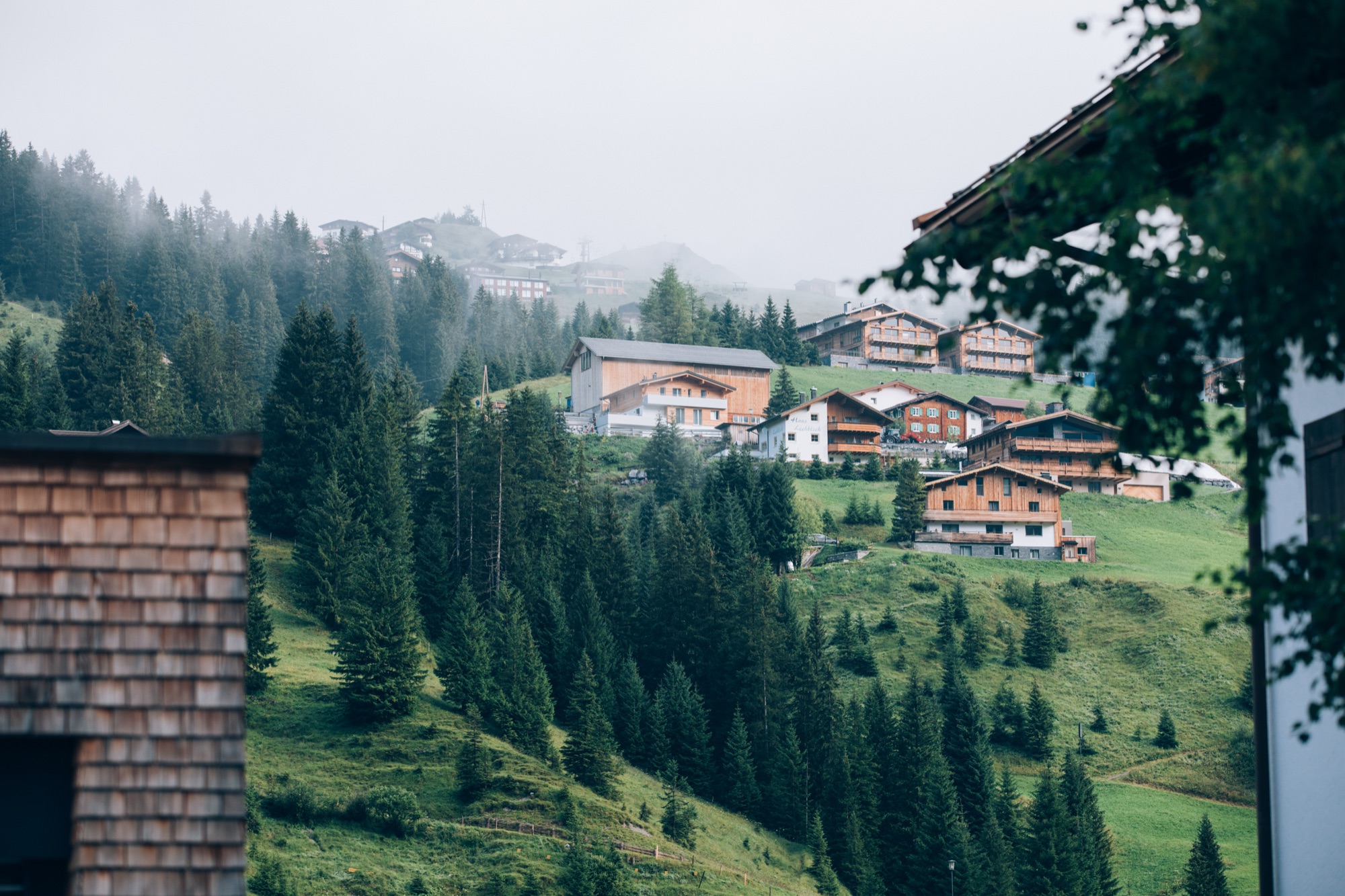 Wolkenverhangene grüne Berghänge über Lech