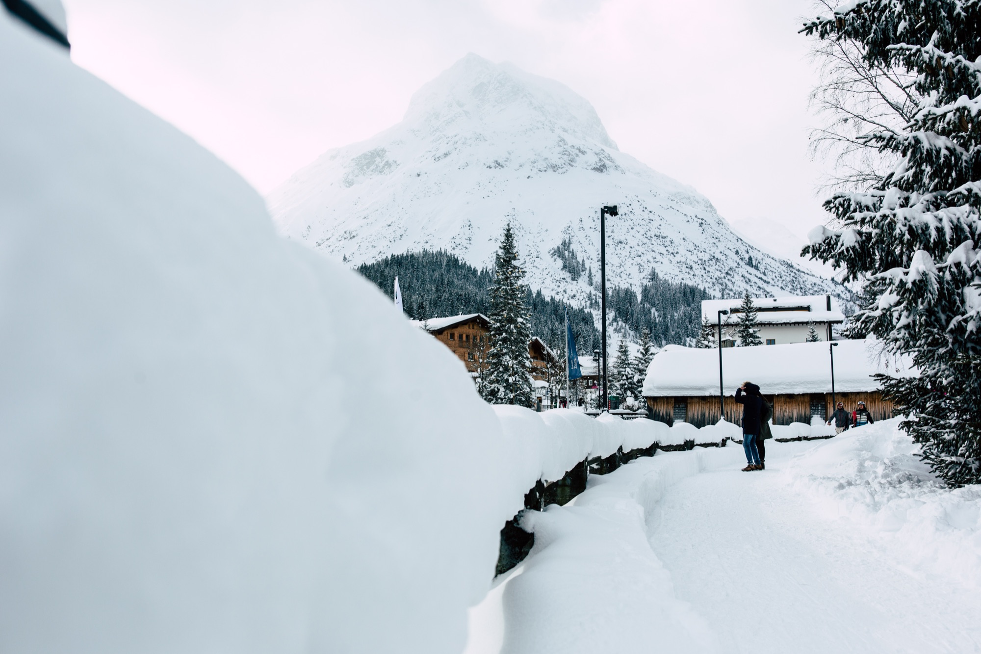 Spaziergang zwischen hohen Schneewänden in Lech am Arlberg